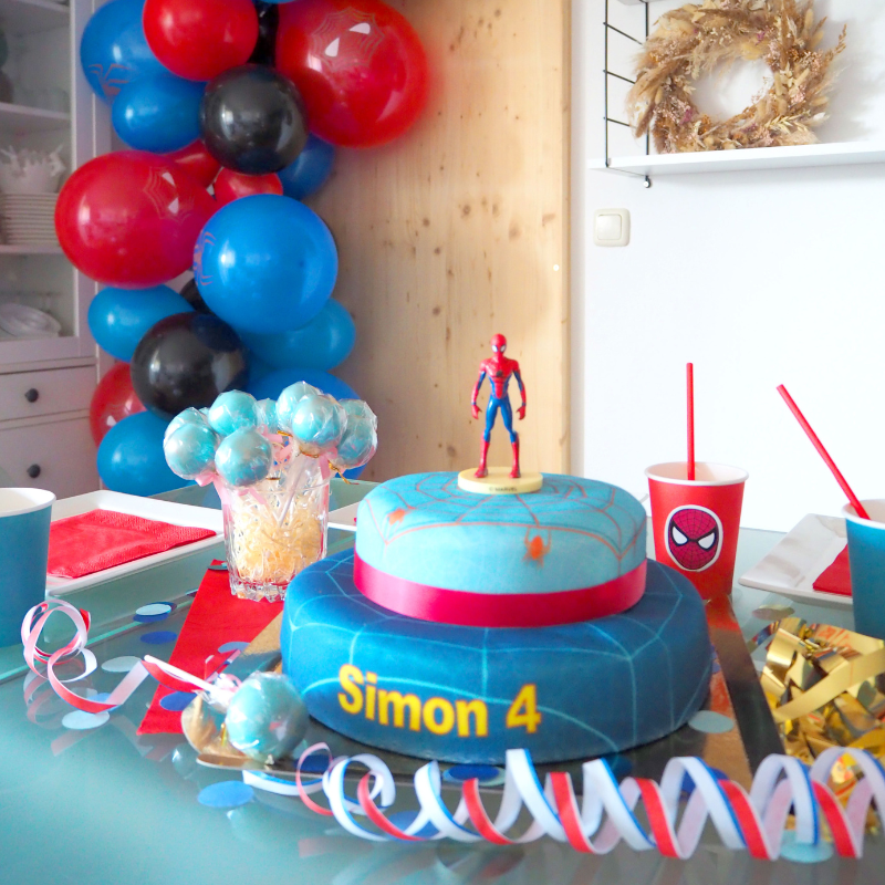 Spider-Man® on a two-tier spider’s web cake with ribbon