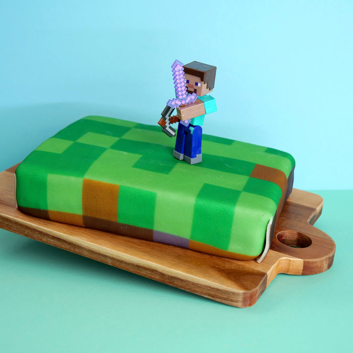 Minecraft® figure on game world cake