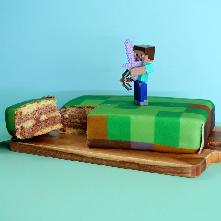 Minecraft® figure on game world cake