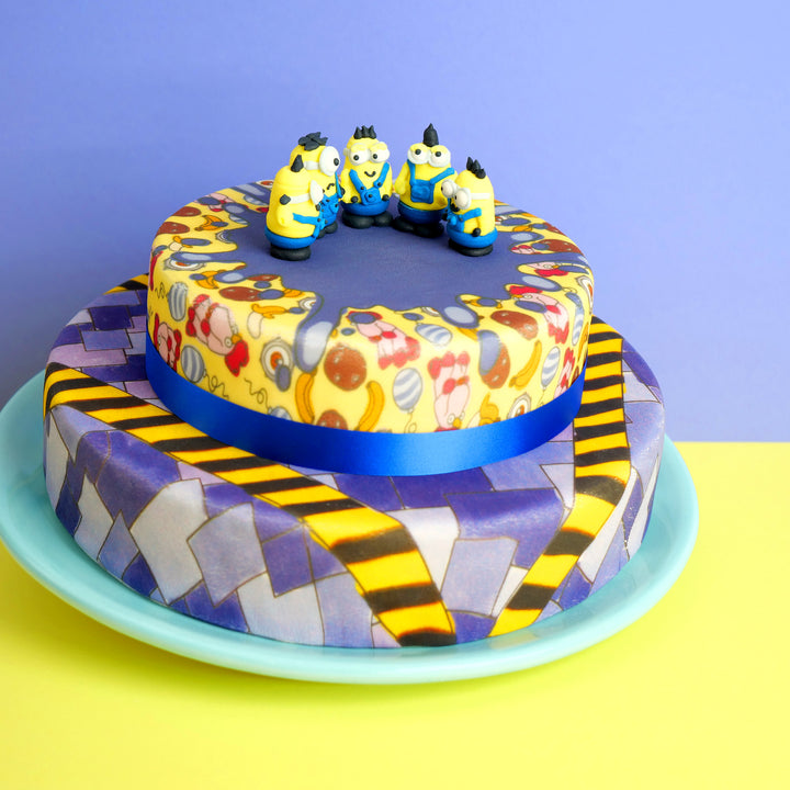 Minions® on a two-tier villainous patterned cake