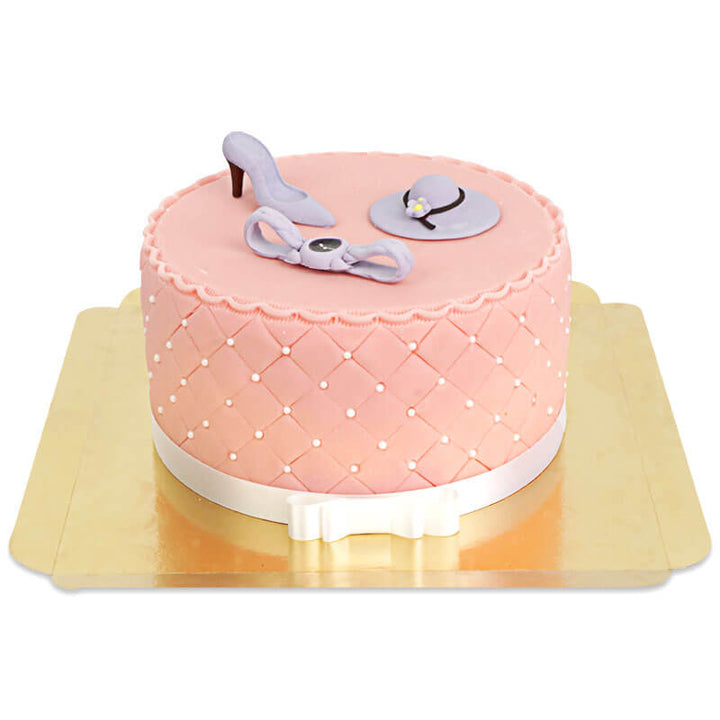 Deluxe make-up cake with colourful sugar decorations and a white ribbon