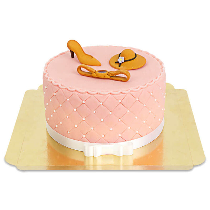 Deluxe make-up cake with colourful sugar decorations and a white ribbon