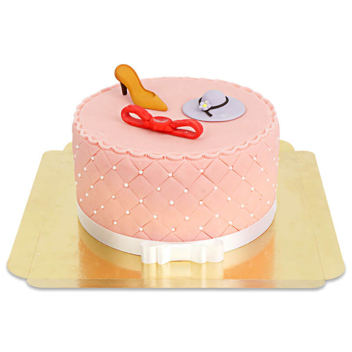 Deluxe make-up cake with colourful sugar decorations and a white ribbon