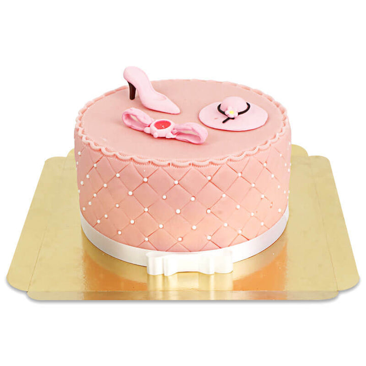 Deluxe make-up cake with colourful sugar decorations and a white ribbon