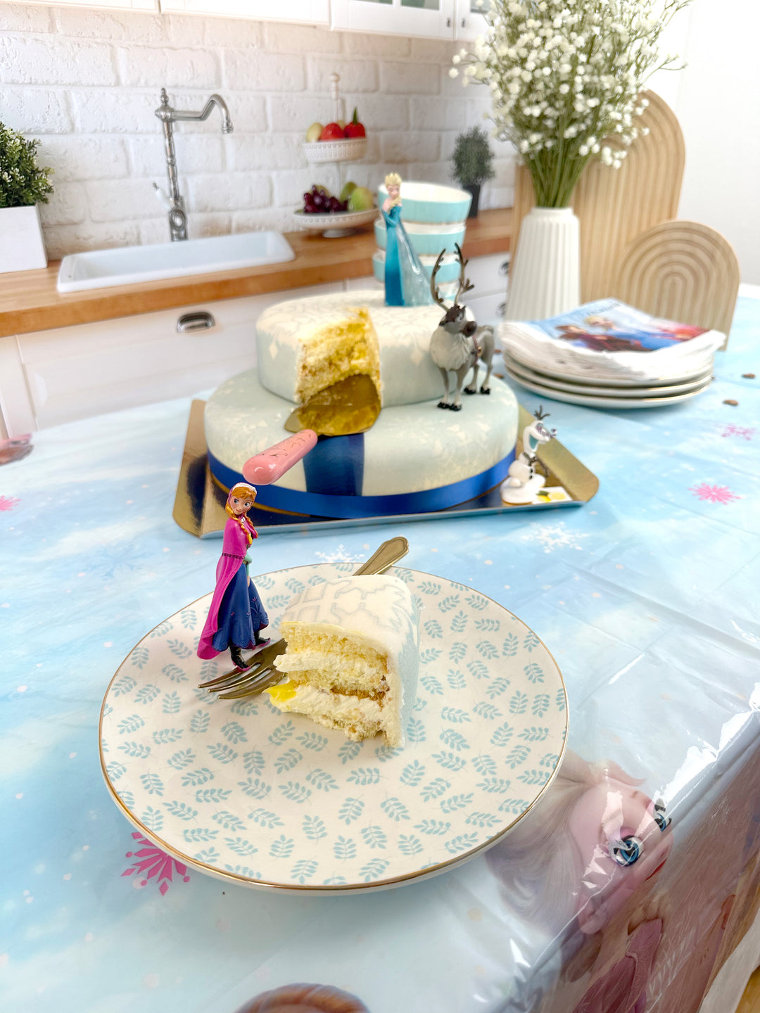 Frozen® Elsa, Anna & Olaf figures on a 2-tier snowflake cake
