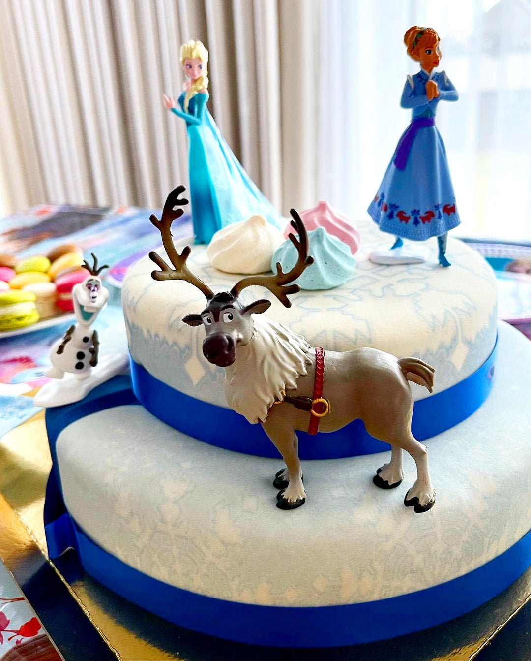 Frozen® Elsa, Anna & Olaf figures on a 2-tier snowflake cake