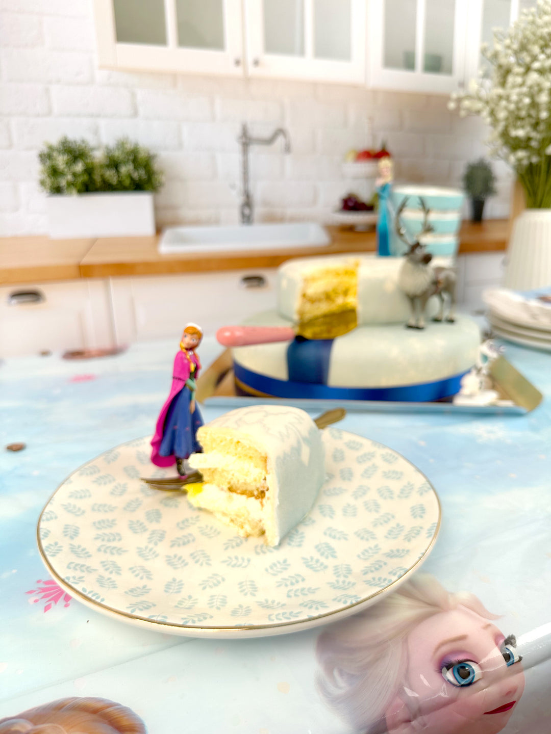 Frozen® Elsa, Anna & Olaf figures on a 2-tier snowflake cake