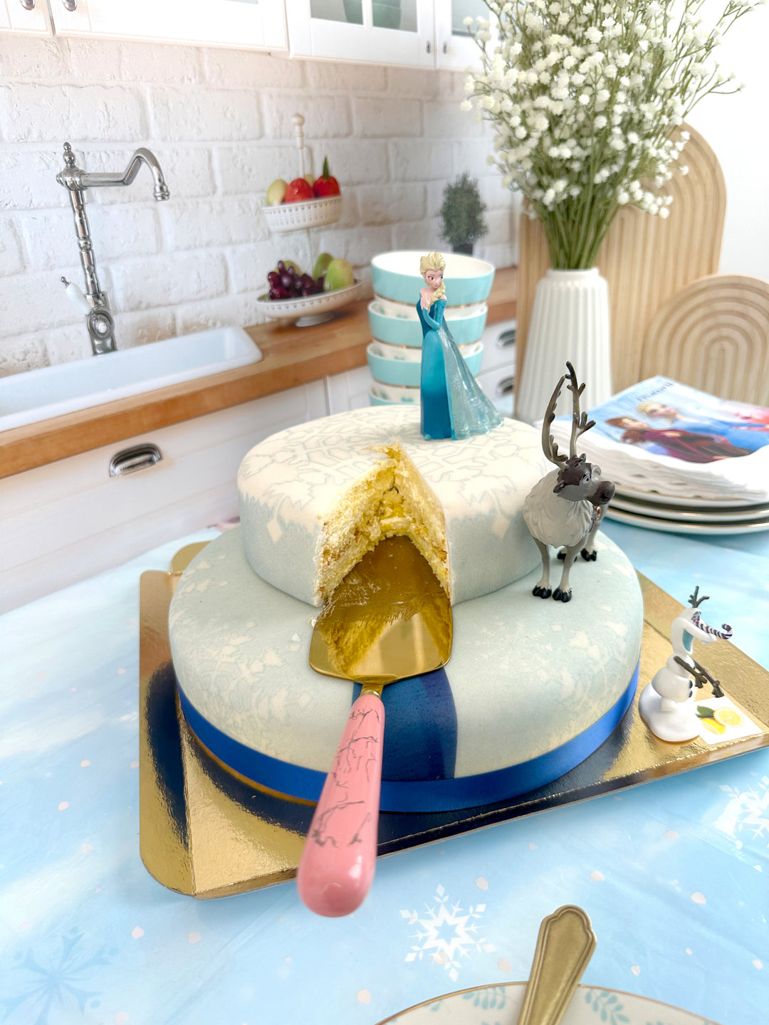 Frozen® Elsa, Anna & Olaf figures on a 2-tier snowflake cake