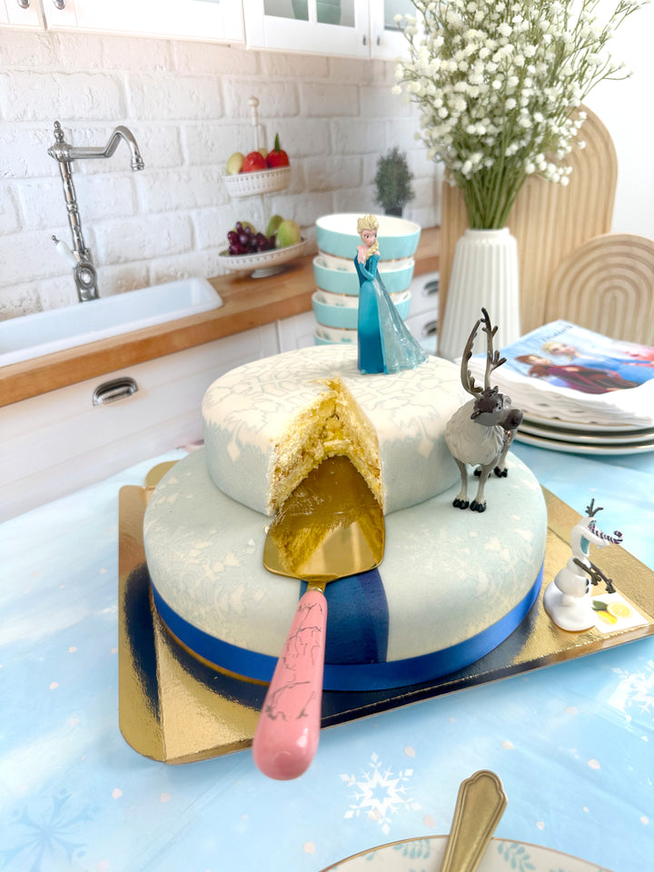 Frozen® Elsa, Anna & Olaf figures on a 2-tier snowflake cake