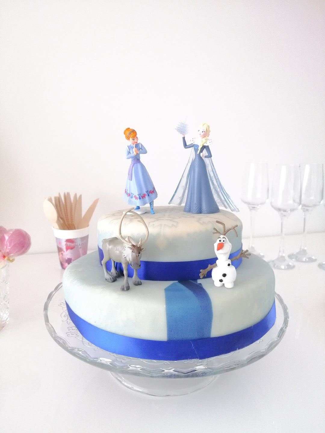 Frozen® Elsa, Anna & Olaf figures on a 2-tier snowflake cake