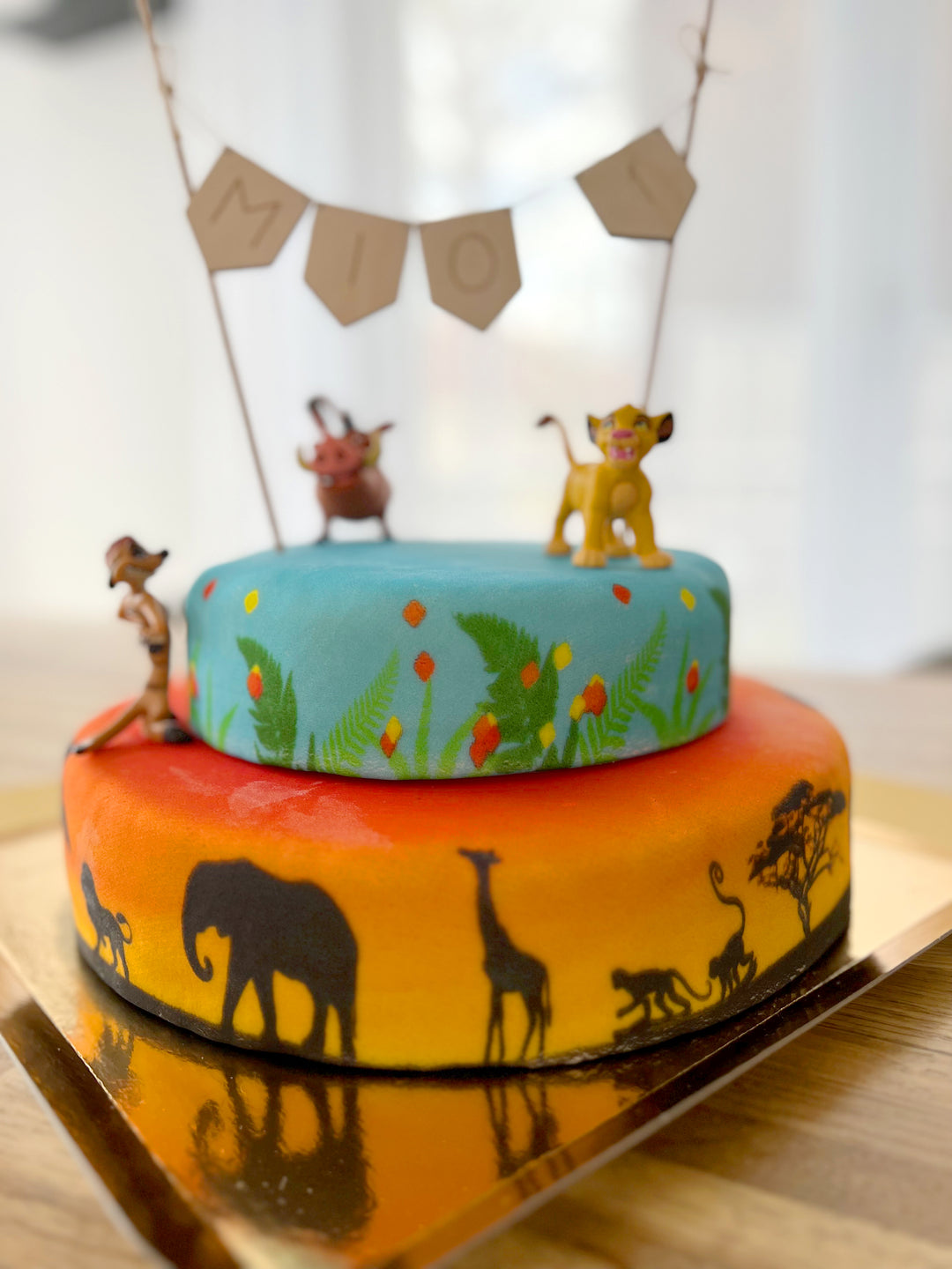 Simba®, Timon & Pumbaa® on a 2-tier savannah cake