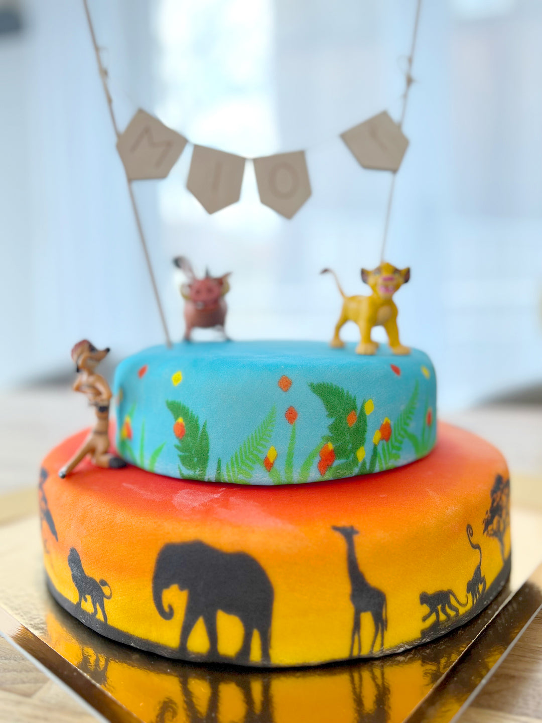 Simba®, Timon & Pumbaa® on a 2-tier savannah cake