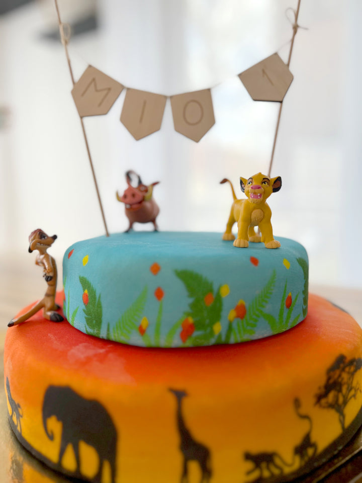 Simba®, Timon & Pumbaa® on a 2-tier savannah cake