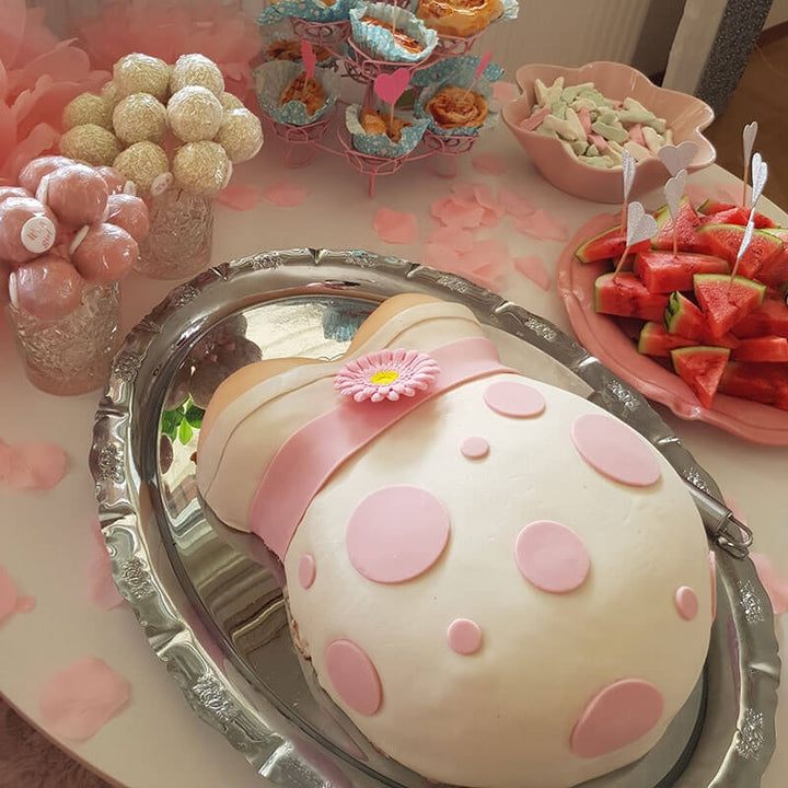 Baby bump cake with pink ribbon