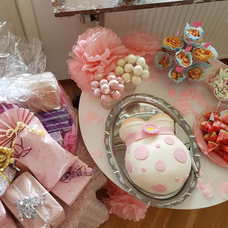 Baby bump cake with pink ribbon
