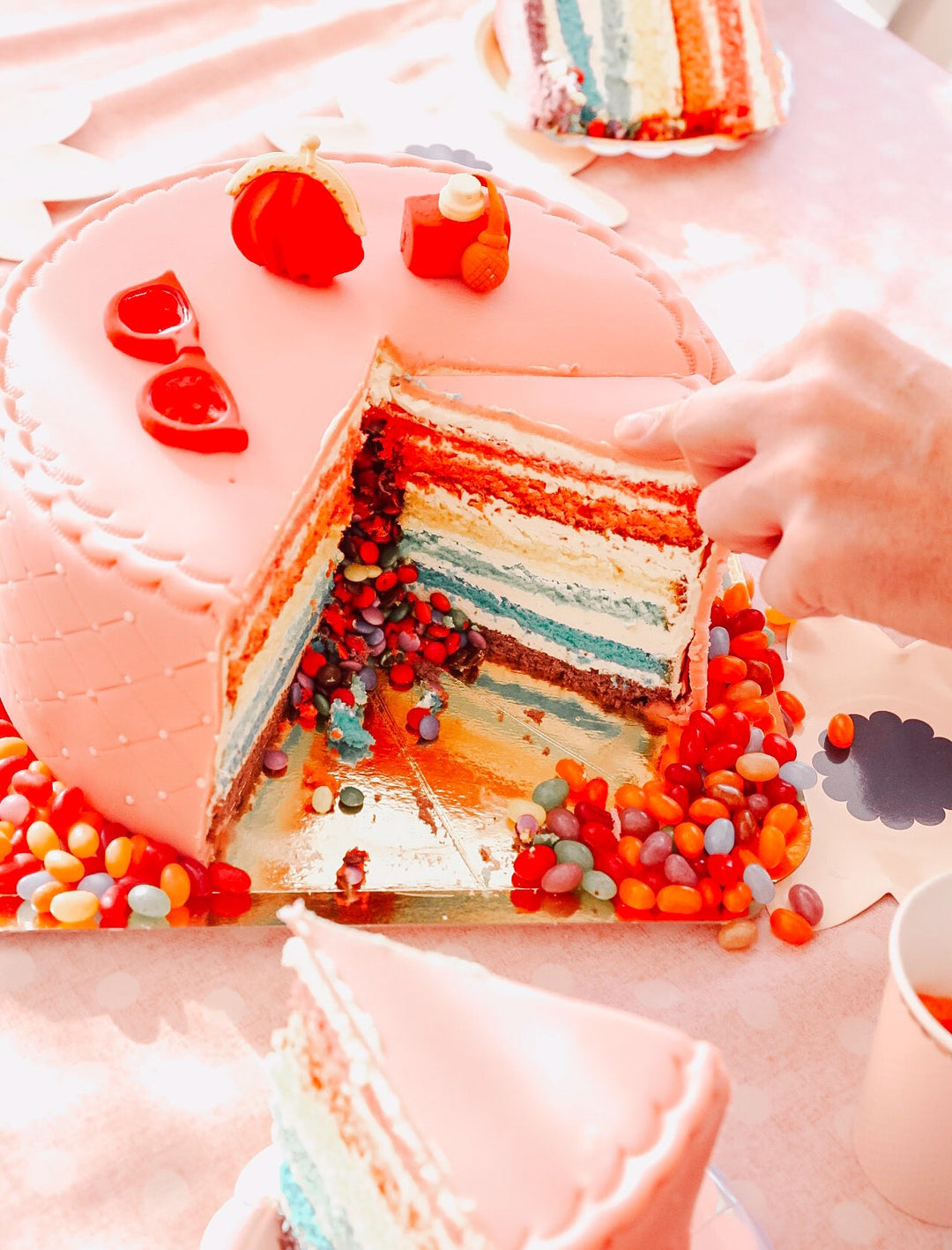 Deluxe make-up cake with colourful sugar decorations and a white ribbon