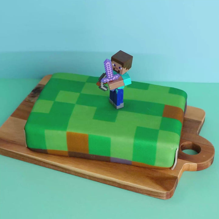 Minecraft® figure on game world cake