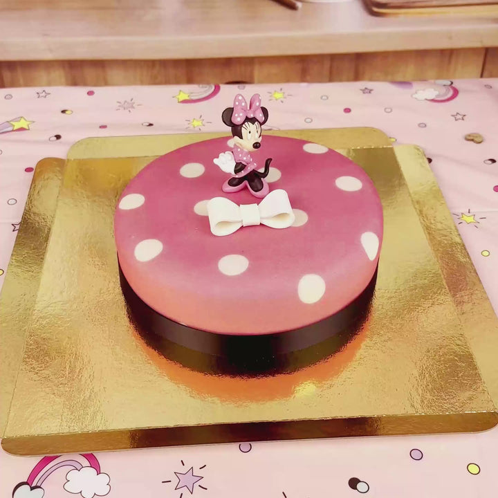 Minnie® Mouse on polka dot cake with ribbon