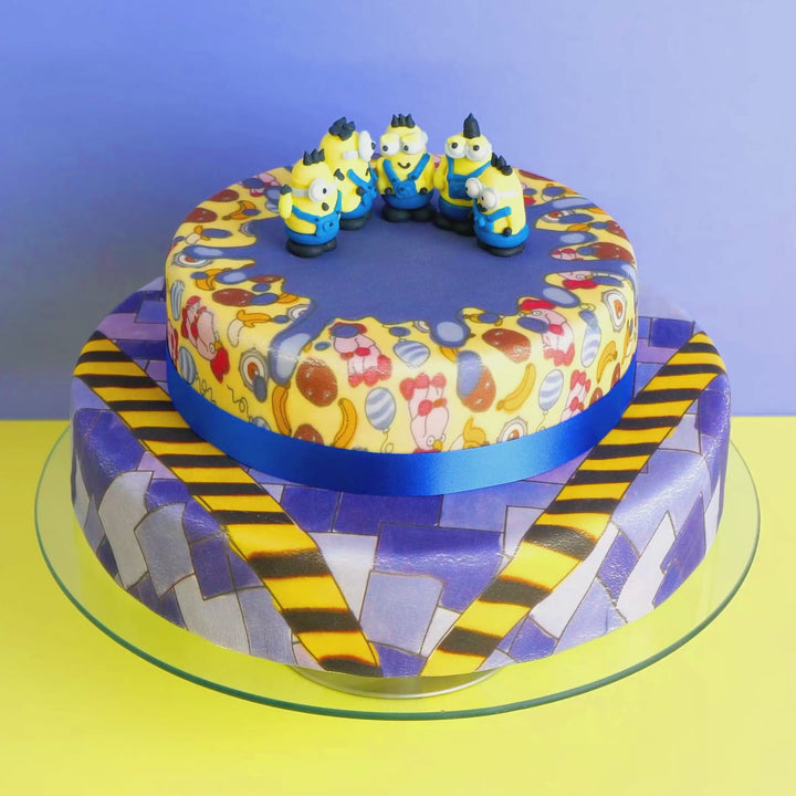 Minions® on a two-tier villainous patterned cake