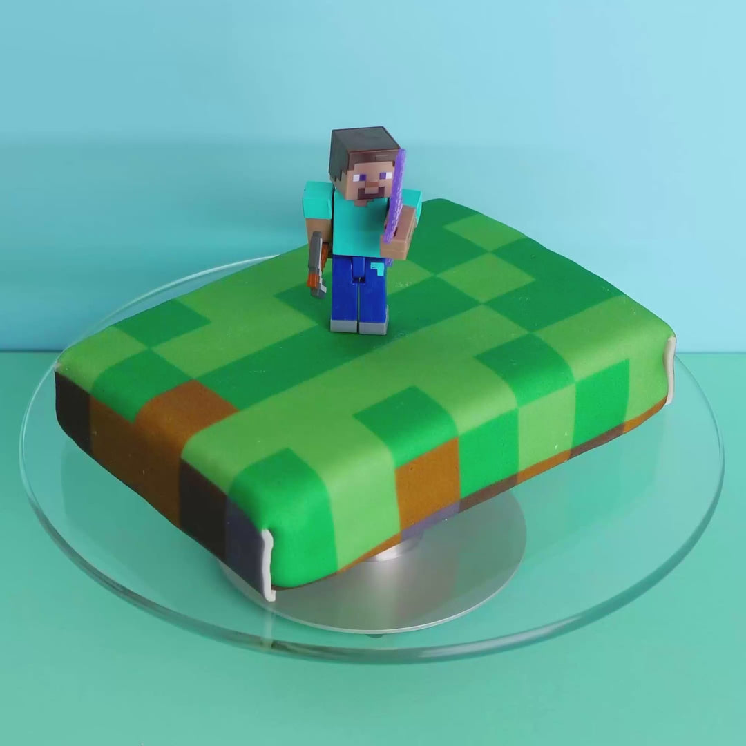 Minecraft® figure on game world cake