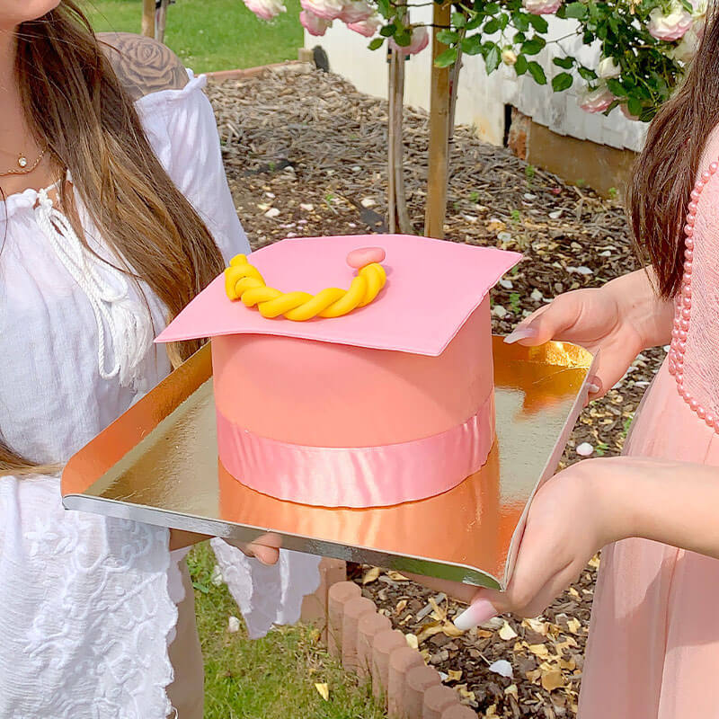 Graduation cake in the shape of a pink graduation cap